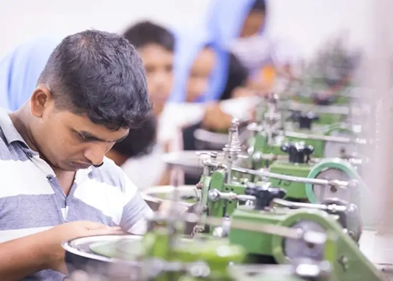Linking operators joining knitwear panels at a sweater factory in Bangladesh